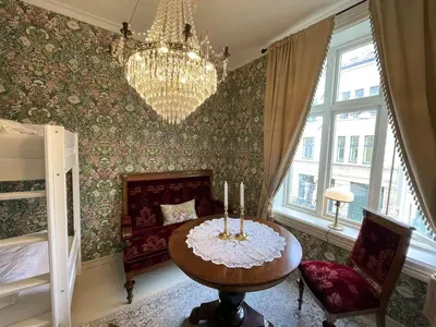 a room with a table and a chandelier and a bedroom at Jugend 1903 in Ålesund