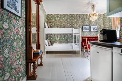 a kitchen with a bedroom with a crib and a living room at Jugend 1903 in Ålesund