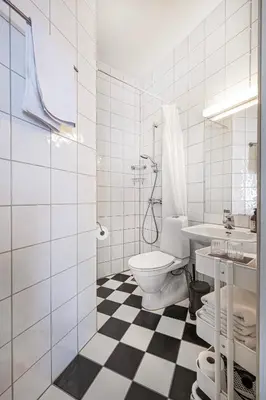 a white bathroom with a toilet and a sink at Jugend 1903 in Ålesund