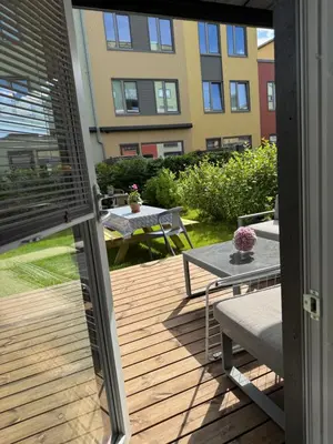 an outside view of a deck with a table and a patio at Modern 4 bedroom townhouse with garden and indoor car park in Trondheim