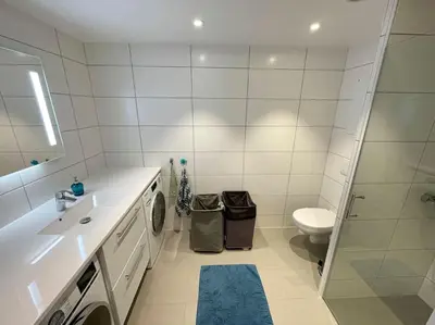 a bathroom with a sink and a toilet and a shower at Modern 4 bedroom townhouse with garden and indoor car park in Trondheim