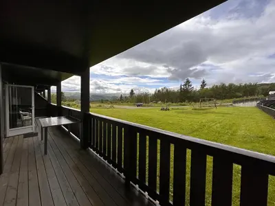 a porch with a view of a field of grass at Charming Ground-Floor Apartment In Beitostølen With Terrace in Beitostøl
