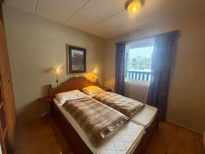 a bedroom with a bed and a window at Charming Ground-Floor Apartment In Beitostølen With Terrace in Beitostøl
