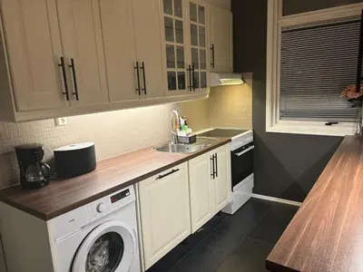 a kitchen with a washing machine and a sink at Fin leilighet nært alt in Bergen