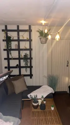 a living room with a couch and potted plants at Fin leilighet nært alt in Bergen