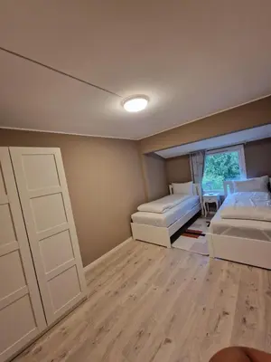 a bedroom with two beds and a window at Eidsvåg in Bergen