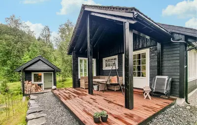 a cabin with a wooden deck with a porch at 3 Bedroom Stunning Home In Vossestrand in Vossestrand