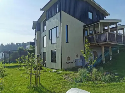 a house on a hill with a yard at New and fresh apartment, free parking and ocean view in Trondheim