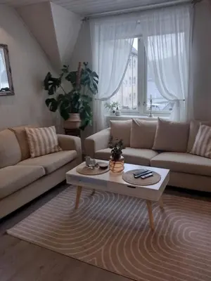 a living room with a couch and a coffee table at Light terrace city apartment Alesund in Ålesund