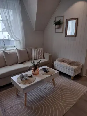 a living room with a couch and a coffee table at Light terrace city apartment Alesund in Ålesund