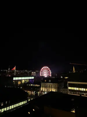 a ferris wheel in a city at night at Penthouse in Trondheim City Centre in Trondheim