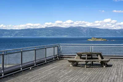 a picnic table sitting on a deck overlooking the water at Penthouse in Trondheim City Centre in Trondheim
