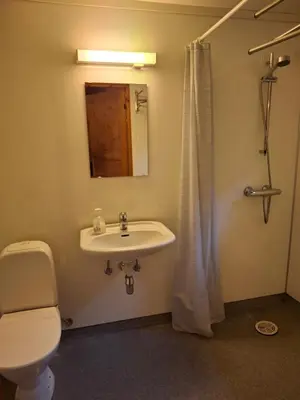 a bathroom with a sink and a toilet and a mirror at Kvanndal Camping in Kvanndal