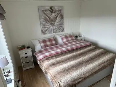a bedroom with a bed with a painting on the wall at Voss Resort self-catered apartments in Skulestadmo