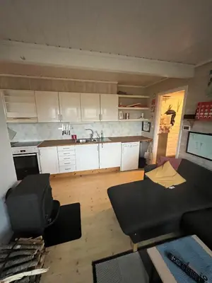 a living room with a couch and a kitchen at Voss Resort self-catered apartments in Skulestadmo