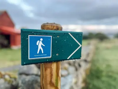 a sign on a wooden post with a person walking at Holiday Home Soltun by Interhome in Flygansvær