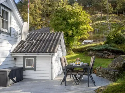 a patio with a table and a small shed at Holiday Home Soltun by Interhome in Flygansvær