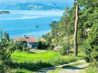 a house on the side of a hill near the water at Holiday Home Blå Hytte by Interhome in Herand