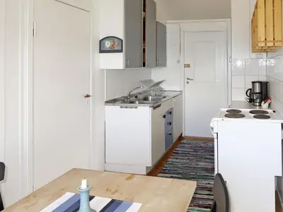 a kitchen with a table and a white refrigerator at Holiday Home Blå Hytte by Interhome in Herand