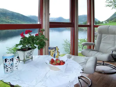 a table with a bowl of fruit on it in front of a window at Holiday Home Strand by Interhome in Vassenden
