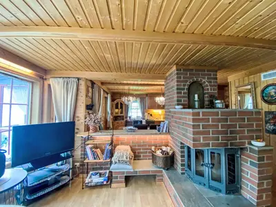 a living room with a brick fireplace and a tv at Holiday Home Strand by Interhome in Vassenden