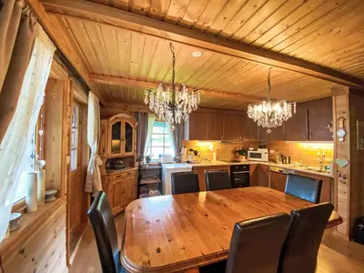 a kitchen with a wooden table and chairs at Holiday Home Strand by Interhome in Vassenden