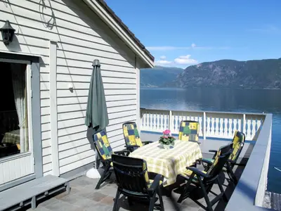 a table and chairs on a porch with a view of the water at Holiday Home Hovsfjellet by Interhome in Fresvik