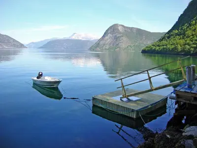a small boat tied to a dock on a lake at Holiday Home Hovsfjellet by Interhome in Fresvik