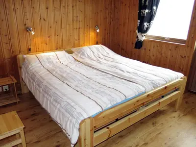 a bed in a wooden room with a window at Holiday Home Hovsfjellet by Interhome in Fresvik