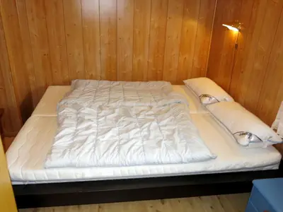 a bed in a room with a wooden wall at Holiday Home Hovsfjellet by Interhome in Fresvik