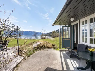 a porch of a house with a table at Holiday Home Sandviki by Interhome in Balestrand