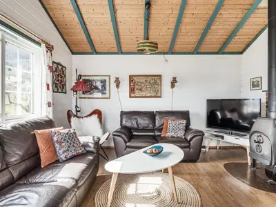 a living room with leather furniture and a flat screen tv at Holiday Home Sandviki by Interhome in Balestrand