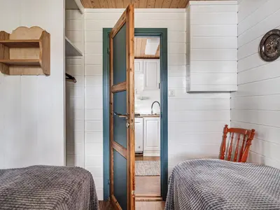 a room with two beds and a door to a bathroom at Holiday Home Sandviki by Interhome in Balestrand