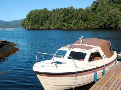 a boat is docked at a dock on a lake at Holiday Home Nystølen by Interhome in Håvik