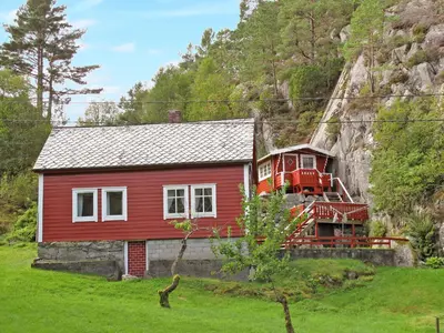 a red house in front of a mountain at Holiday Home Laksevågen by Interhome in Bruntveit