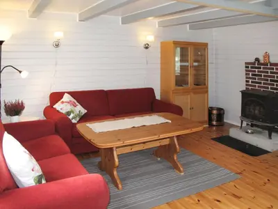 a living room with a red couch and a coffee table at Holiday Home Laksevågen by Interhome in Bruntveit