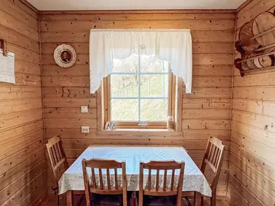 a dining room with a table and a window at Holiday Home Pærehagen by Interhome in Balestrand