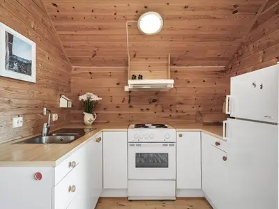 a kitchen with white appliances and wooden walls at Holiday Home Veganeset II by Interhome in Balestrand