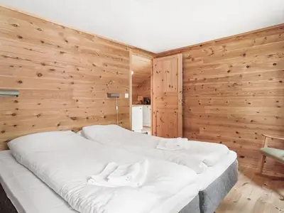 a large white bed in a room with wooden walls at Holiday Home Veganeset II by Interhome in Balestrand