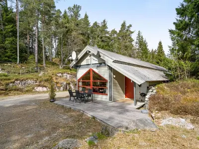 a small cabin with a porch and two chairs on a deck at Holiday Home Veganeset II by Interhome in Balestrand