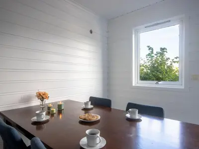 a dining room with a table and a window at Holiday Home Nesjaholmen by Interhome in Kalavåg