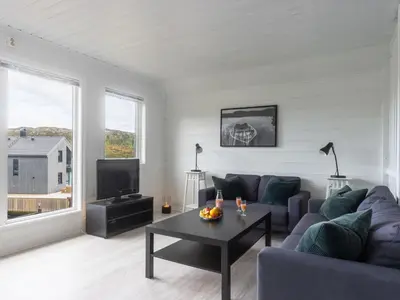 a living room with a couch and a table at Holiday Home Nesjaholmen by Interhome in Kalavåg