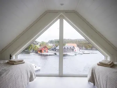 two beds in a room with a large window at Holiday Home Pale by Interhome in Bømlo