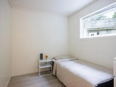 two beds in a small room with a window at Holiday Home Pale by Interhome in Bømlo
