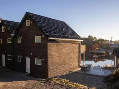 a large wooden house with a dock next to a body of water at Holiday Home Pale by Interhome in Bømlo