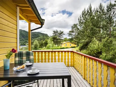 a wooden deck with a table and chairs on it at Holiday Home Solbakken by Interhome in Gjølanger