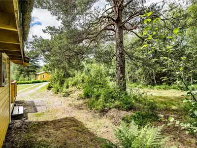 a house with a tree on the side of a road at Holiday Home Solbakken by Interhome in Gjølanger