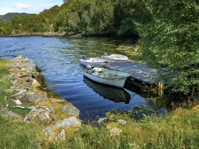 two boats are docked at a dock on a lake at Holiday Home Solbakken by Interhome in Gjølanger