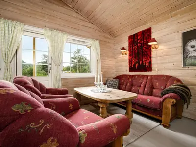 a living room with red furniture and a table at Holiday Home Solbakken by Interhome in Gjølanger