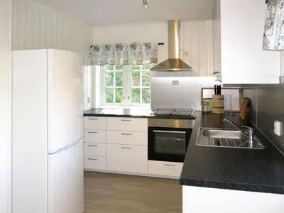 a kitchen with white appliances and a black counter top at Holiday Home Nesjevik by Interhome in Bø